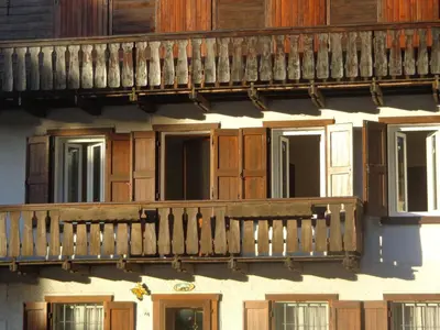 a building with a wooden balcony and windows at Appartamento Lidia Astor in Alleghe