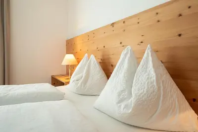 a bedroom with two beds with white sheets and pillows at Landhaus am Gries in Lana