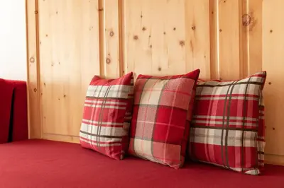 two red and white pillows sitting against a wall at Landhaus am Gries in Lana