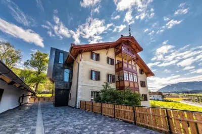 a house with a wooden fence in front of it at Niedermairhof in Brunico