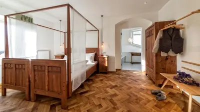 a bedroom with a bed and a wooden floor at Niedermairhof in Brunico