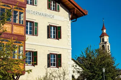 a building with a clock tower in the background at Niedermairhof in Brunico