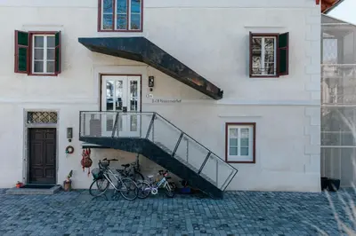 a building with bikes parked in front of a staircase at Niedermairhof in Brunico