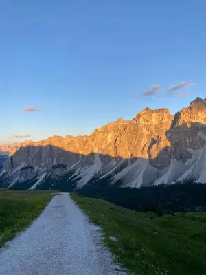 a dirt road in front of a mountain range at Appartamenti la Fontana in San Martino in Badia