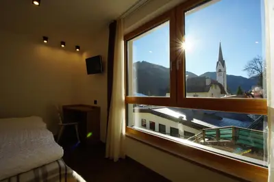 a bedroom with a window with a view of a church at Chalet Apartments Ambria in La Villa