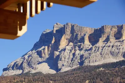 a large mountain with trees in front of it at Chalet Apartments Ambria in La Villa