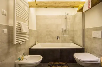 a bathroom with a tub and a toilet and a sink at Chalet Da Mont in Selva di Val Gardena