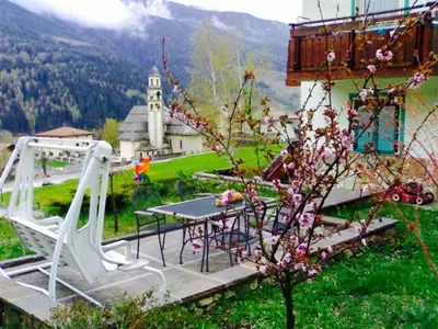 a patio with a table and chairs and a building at Roe Apartment in Panchia