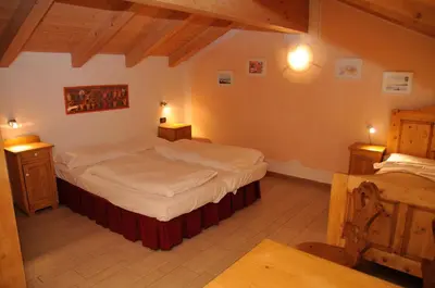 a bedroom with two beds and two night stands at Roe Apartment in Panchia