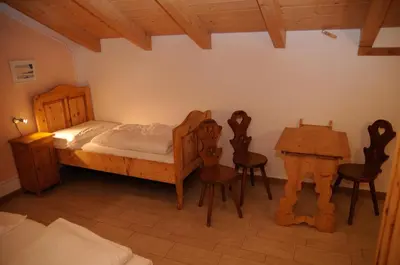 a bedroom with a bed and a table and chairs at Roe Apartment in Panchia