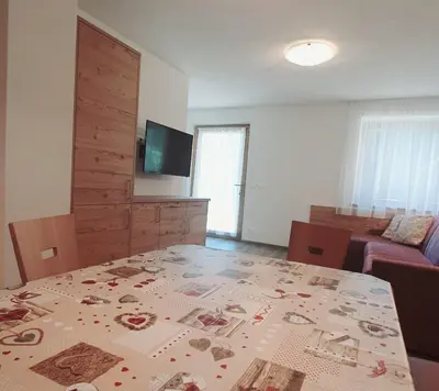 a living room with a table and a couch at Residence Majarai in Colfosco