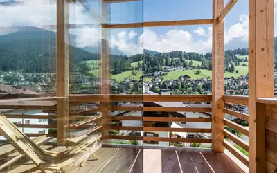 a wooden table and chairs and a table and a table at Chalet Sophia in Ortisei