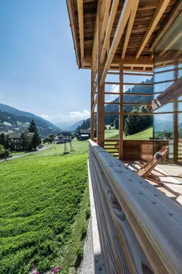 a patio with two lawn chairs and an umbrella at Chalet Sophia in Ortisei