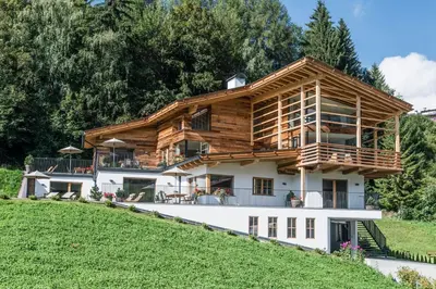a living room with a gray couch and a kitchen at Chalet Sophia in Ortisei