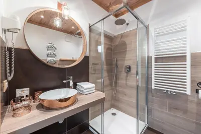 a bedroom with a large bed and a wooden ceiling at Albergo Majorka in Canazei