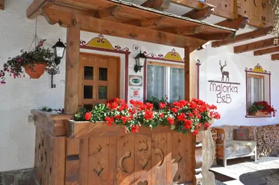 a bedroom with a large bed and a bathroom at Albergo Majorka in Canazei