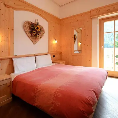 a bedroom with a large bed and a television at La Campagnola in Canazei