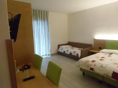 a hotel room with two beds and a window at Garni Festil in Campitello di Fassa