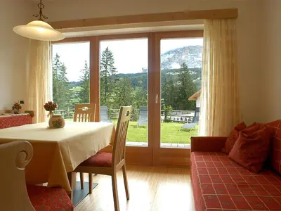 a dining room with a table and a large window at Chalet Susi in La Villa