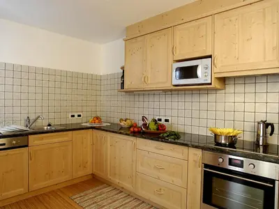 a kitchen with wooden cabinets and a microwave at Chalet Susi in La Villa
