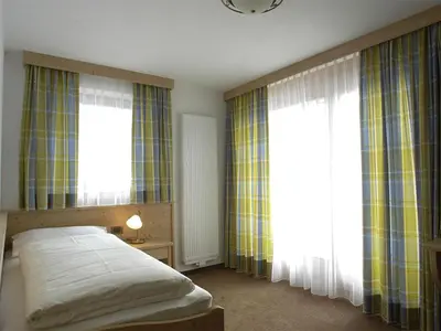 a bedroom with a bed and two large windows at Chalet Susi in La Villa