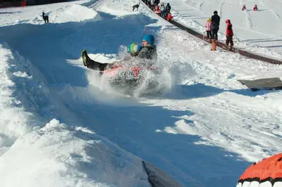 a person riding a snowmobile down a snow covered slope at Pension Widmann in Stulles