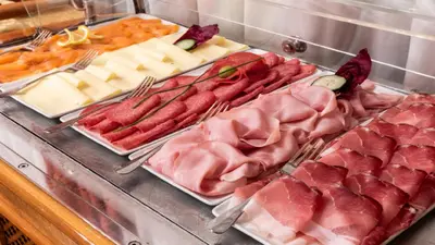 a bunch of meats and cheeses and other foods at Cityhotel Goldener Adler B&B in Chiusa