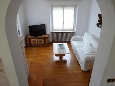a living room with a white couch and a coffee table at Appartamento Sole in Borca di Cadore