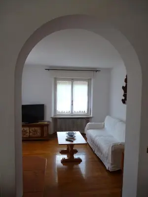 a living room with a white couch and a table at Appartamento Sole in Borca di Cadore