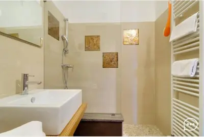 a white bathroom with a sink and a shower at Tirso Apartament in Castello di Fiemme
