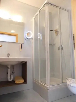 a bathroom with a shower and a sink at Garni Hotel Dorothea in Tirolo