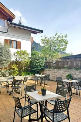 a group of tables and chairs on a patio at Garni Hotel Dorothea in Tirolo