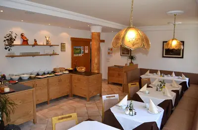 a restaurant with white tables and a dining room at Garni Hotel Dorothea in Tirolo