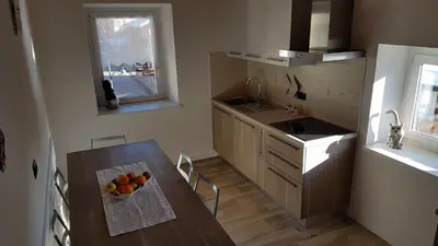 a kitchen with a table with a bowl of fruit on it at Casa Paola in Pozza di Fassa