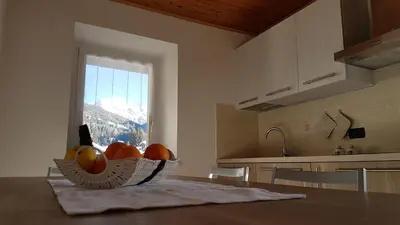 a kitchen with a bowl of fruit on a table at Casa Paola in Pozza di Fassa
