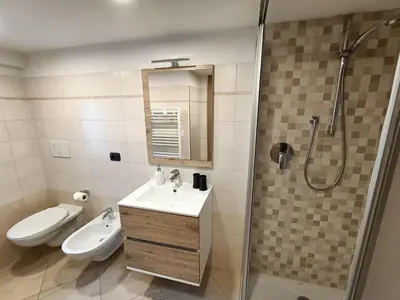 a bathroom with a sink and a shower and a toilet at Casa Paola in Pozza di Fassa