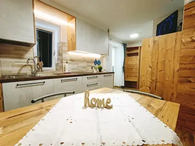 a kitchen with a table with a home sign on it at Casa Paola in Pozza di Fassa