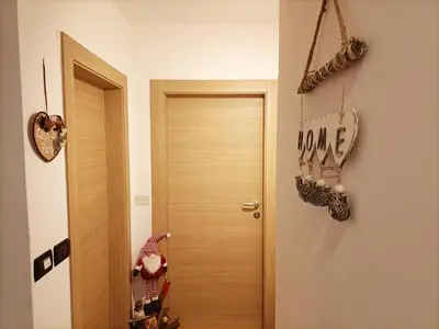 a hallway with a door and a sign that reads love at Casa Paola in Pozza di Fassa