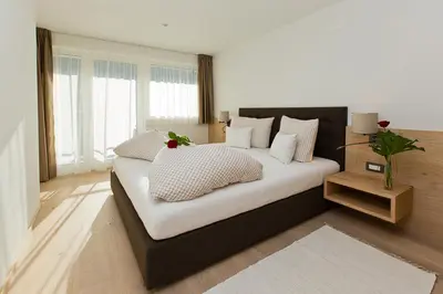 a bedroom with a large bed with white sheets and pillows at Villa Ried in Perca