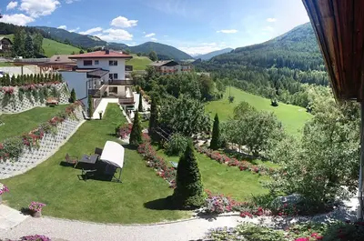 a view of a garden with a house and mountains at Villa Ried in Perca