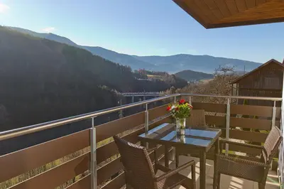 a table with a vase of flowers on a balcony at Villa Ried in Perca