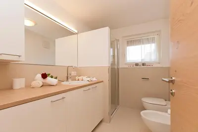 a white bathroom with a toilet and a sink at Villa Ried in Perca