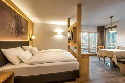 a bedroom with a bunk bed and a table at Garni Larix in Colfosco