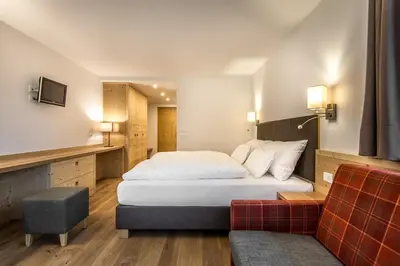 a hotel room with a bed and a couch at Garni Larix in Colfosco