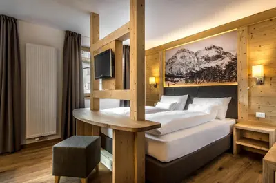 a hotel room with a bed and a table at Garni Larix in Colfosco