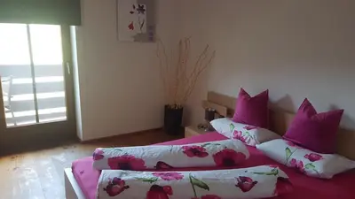 a bedroom with two beds with pink and white pillows at Partschillerhof in Fiè