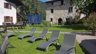 a group of chairs sitting on the grass in front of a building at Partschillerhof in Fiè
