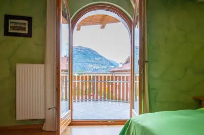 a bedroom with an open door to a balcony at Isarco Suite in Vipiteno
