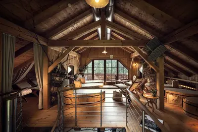 an attic room with wooden ceilings and a large window at Almhotel Lenz in Valdaora