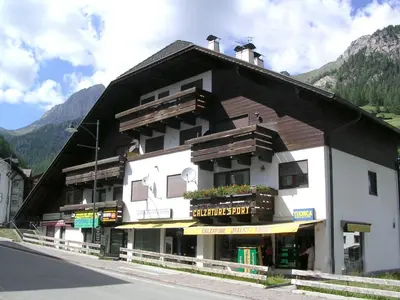 a large building on the side of a street at La Casa Duron in Campitello di Fassa